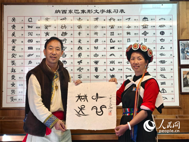 人民網(wǎng)“行進中國”云南調(diào)研采訪團走進麗江，和閏元現(xiàn)場用東巴文寫下“行進中國”。人民網(wǎng)記者 符皓攝