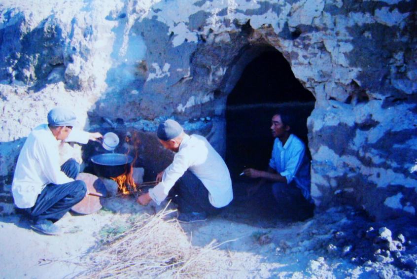 1983年，“六老漢”一代治沙人在“地窩子”生活做飯。新華社發(fā)（八步沙林場供圖）