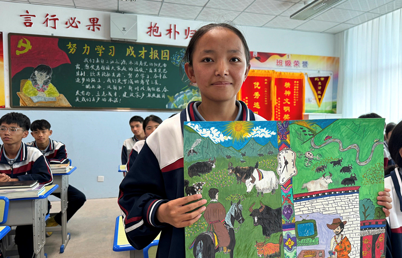 果洛西寧民族中學(xué)學(xué)生尼東拉毛在主題思政課上展示表現(xiàn)現(xiàn)代化家鄉(xiāng)的作品。