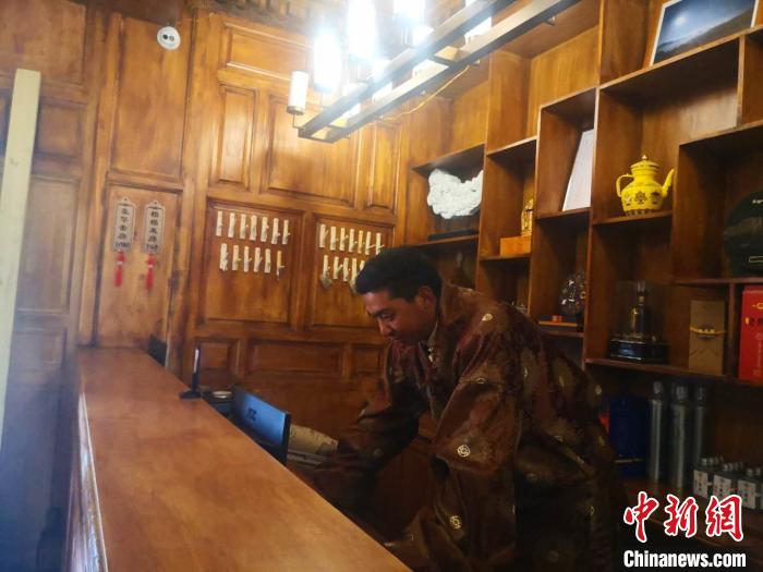 圖為桑杰才讓用電腦處理財務(wù)?！∈缝o靜 攝