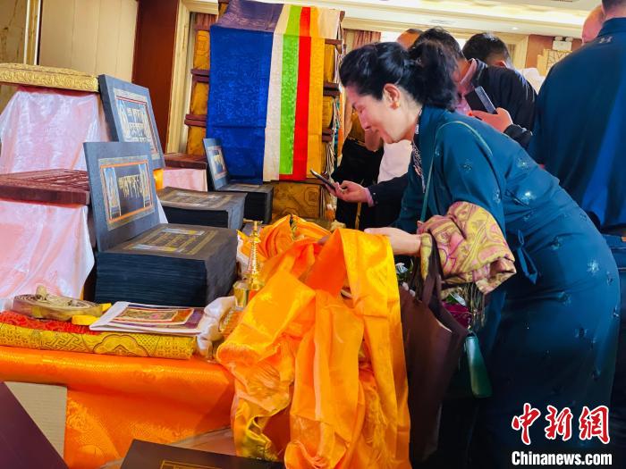 圖為現(xiàn)場藏族民眾向黃金書寫的大藏經(jīng)《甘珠爾》敬獻哈達?！O睿 攝
