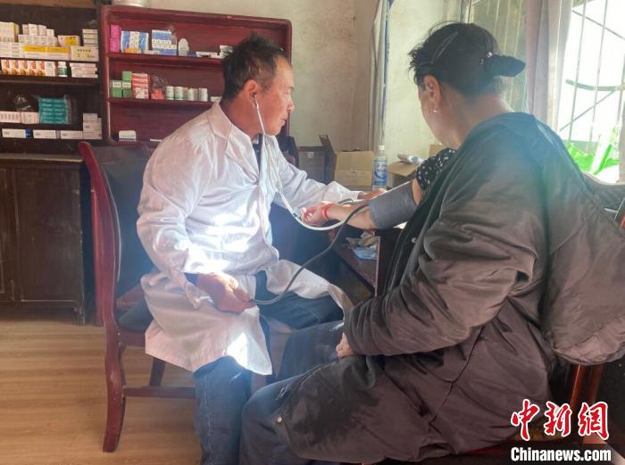 索木滾(左)為村民看病?！∪捞量h委宣傳部供圖