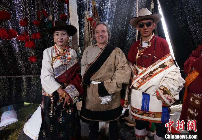 圖為一名外籍?dāng)z影師(中)身穿藏服和藏族民眾合影留念。　馬銘言 攝