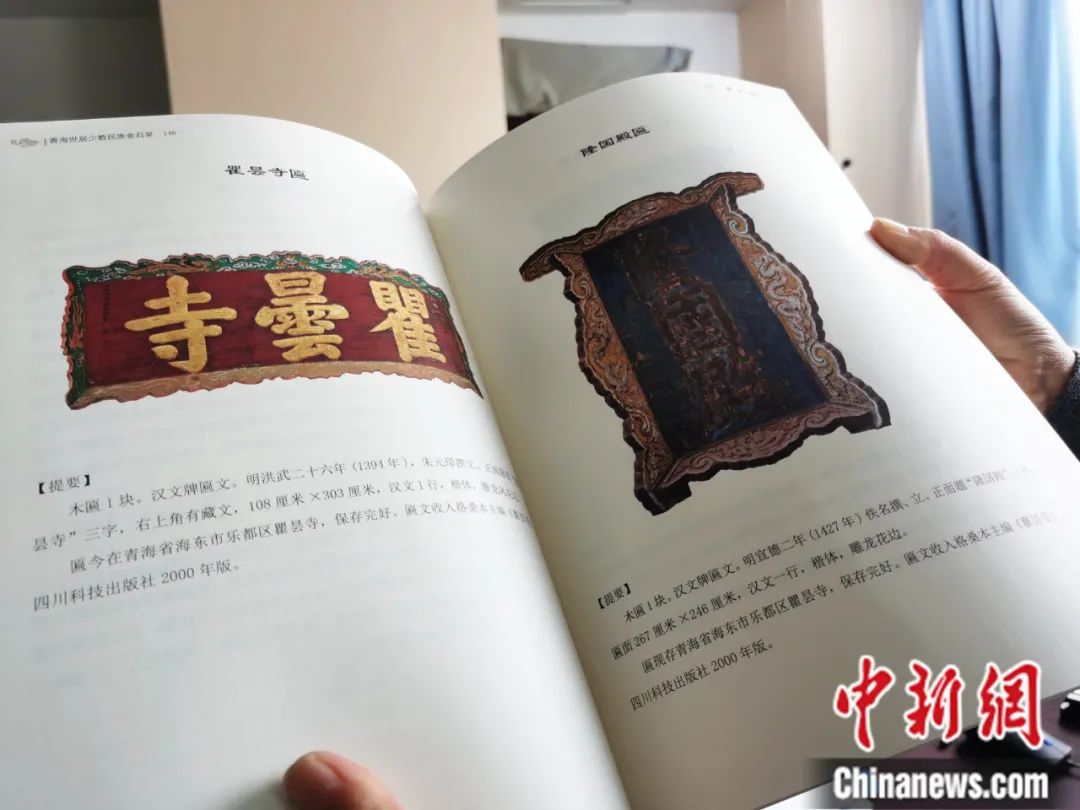 古籍保護人員展示介紹明代朱元璋撰寫的青海瞿曇寺匾(左)的出版書籍。張?zhí)砀?攝