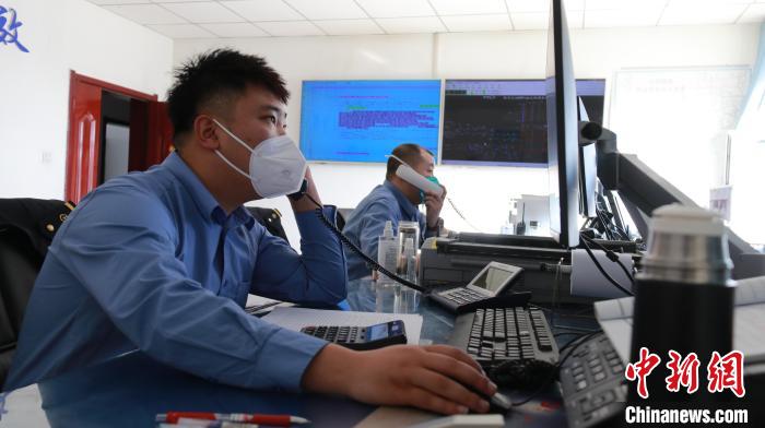 圖為貨運調(diào)度人員與外勤工作人員聯(lián)系掌握車輛裝載情況?！±钌?攝