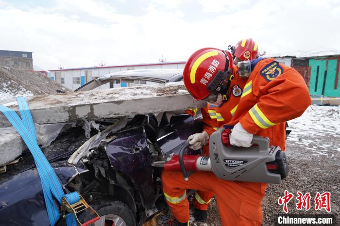 圖為地震實戰(zhàn)拉動現(xiàn)場，參演人員進行車輛破拆。　玉樹消防供圖
