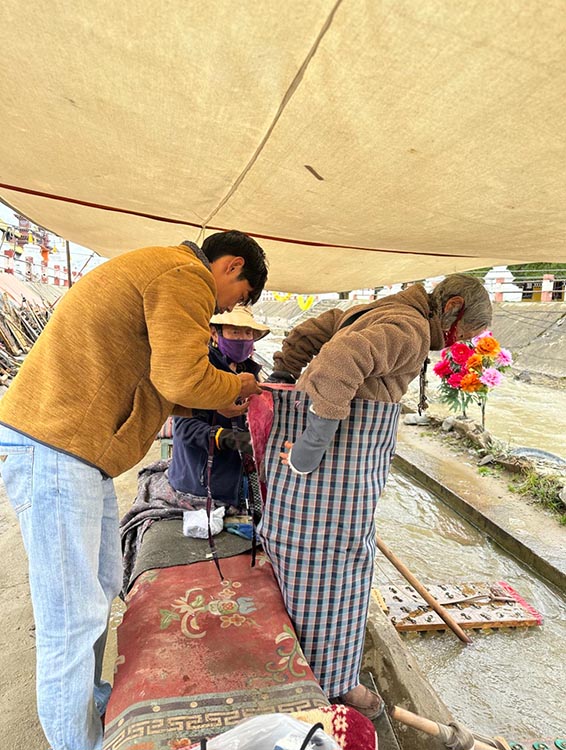 扎西奪爾登為路邊老人送去保暖圍腰。阿壩州文明辦供圖