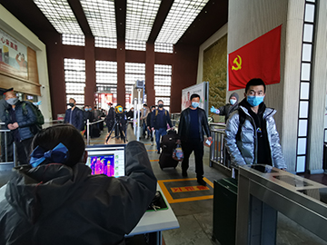 拉薩火車站工作人員對出站旅客進行紅外線測溫。趙越拍攝.jpg