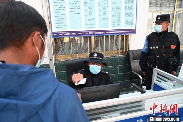 圖為移民管理警察登記完身份信息后將證件歸還給行人。　趙朗 攝