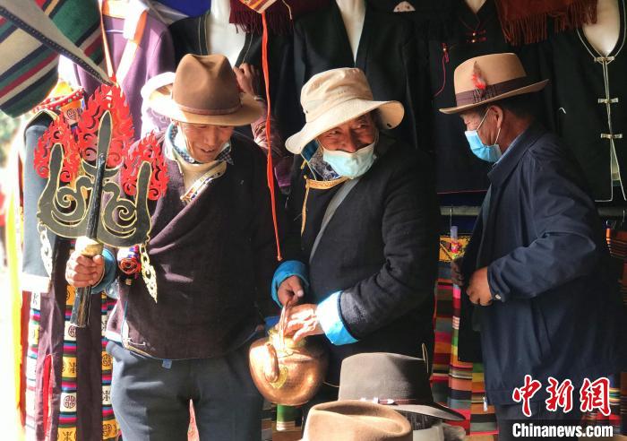 圖為三位藏族老人在集市上聊天交談?！∪轿木?攝