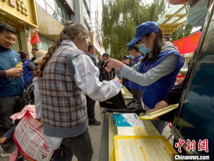 圖為志愿者為市民發(fā)放網絡安全宣傳手冊?！≈x牧 攝