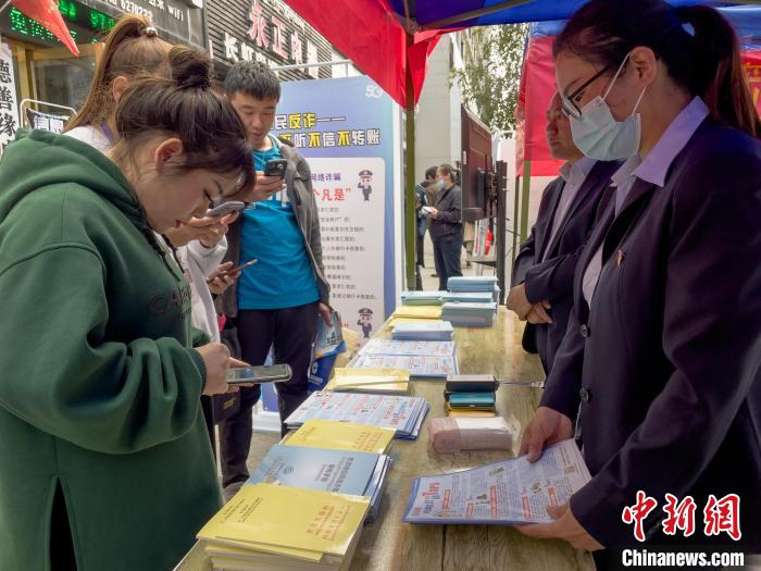 圖為工作人員正在向路過市民介紹國家反詐中心軟件的功能。　謝牧 攝
