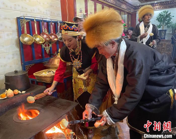 圖為人們?cè)诨鹕峡竟?jié)日美食“結(jié)達(dá)”?！∪轿木?攝