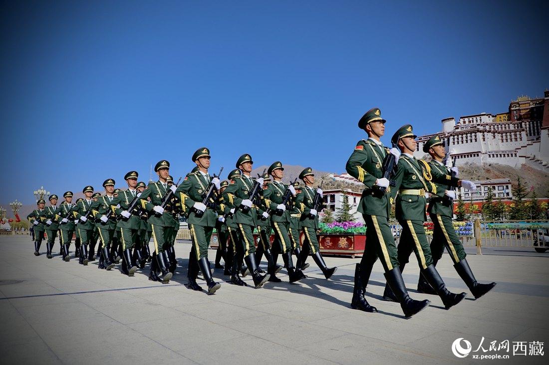 國旗護(hù)衛(wèi)隊隊員緊握鋼槍，踏著威武雄壯的步伐，走向國旗臺。人民網(wǎng) 次仁羅布攝