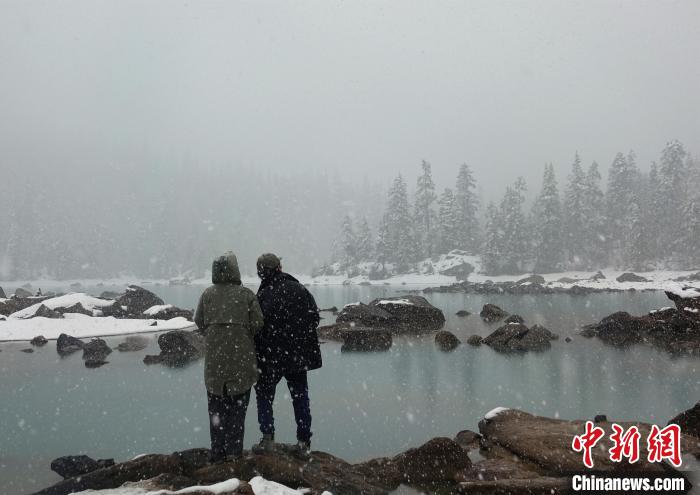 游客欣賞雪中然烏湖。　冉文娟 攝