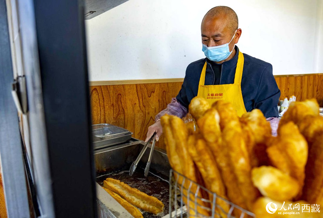 早餐店老板正在炸油條。人民網(wǎng) 次仁羅布攝