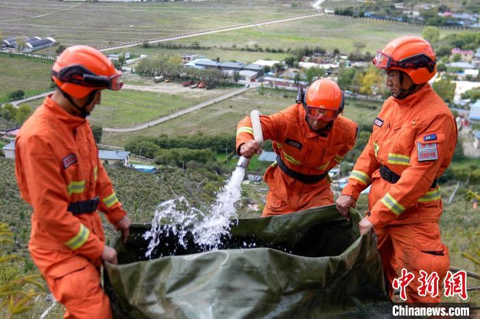 技能大練兵過程中，消防員在陡坡上向蓄水池注水?！±顕鵂c 攝