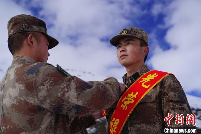 排長(zhǎng)王朝偉(圖左)給退伍老兵佩戴大紅花?！∥鞑厣侥宪姺謪^(qū)某團(tuán)供圖