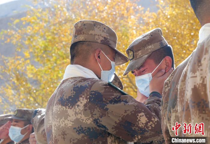 圖為什布奇邊防連退伍老兵與戰(zhàn)友相擁而泣，依依惜別?！⌒觳?攝