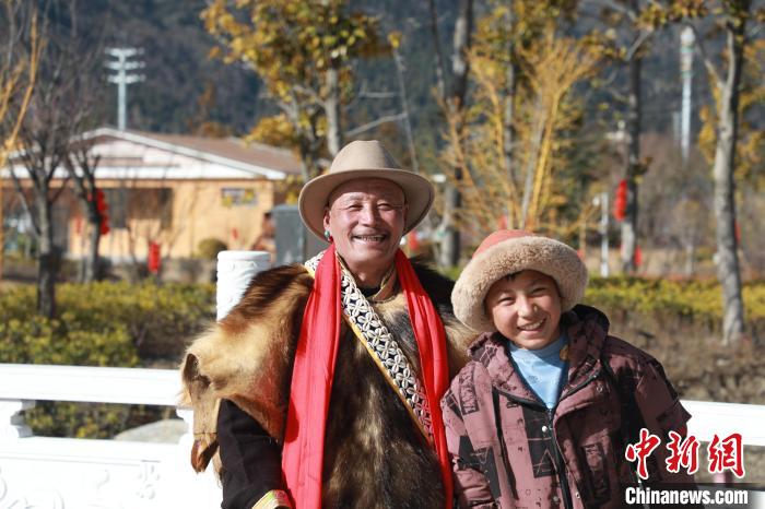 圖為林芝市巴宜區(qū)布久鄉(xiāng)仲果村村民桑杰與孫子一起參加藏歷新年活動。　張力 攝