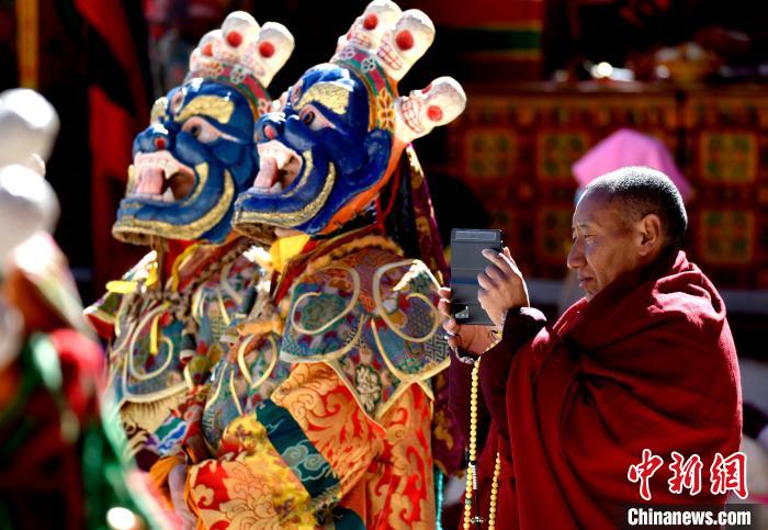 2月19日，正在拍攝跳神活動(dòng)的僧人?！±盍?攝