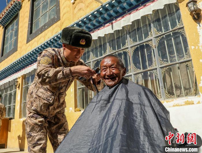 圖為阿里軍分區(qū)某邊防團官兵為駐地群眾理發(fā)迎藏歷新年。　旦增倫珠 攝