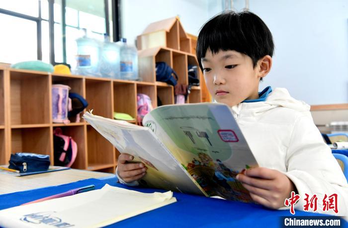 3月14日，西藏拉薩市第一小學(xué)一年級(jí)六班學(xué)生丁增樂吉在閱讀藏語課本?！±盍?攝