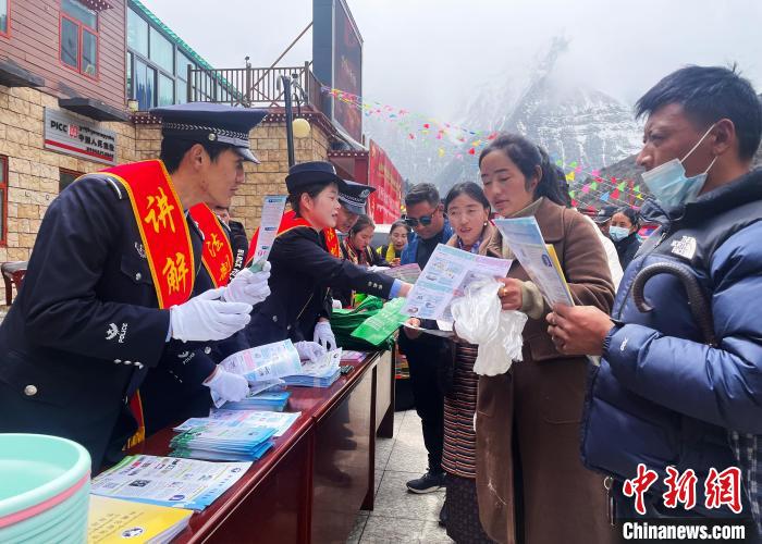 圖為山南玉麥邊境派出所民警為轄區(qū)群眾發(fā)放法律知識宣傳單?！＄婗?　攝