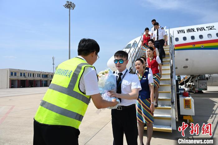 圖為機(jī)組順利抵達(dá)后獲贈祝賀?！≮w朗 攝