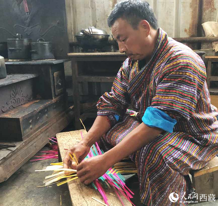 門巴族漢子愛明正在編織藤竹品。
