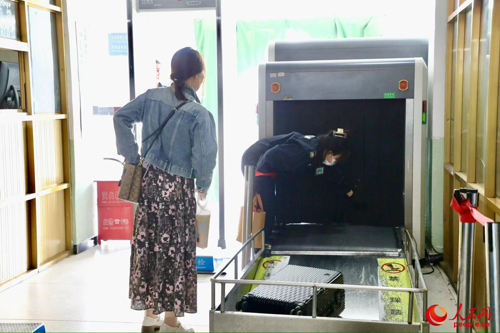 車站工作人員幫旅客提取行李。人民網(wǎng)記者 次仁羅布攝