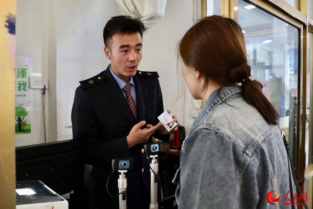 車站工作人員向旅客解答疑問(wèn)。人民網(wǎng)記者 次仁羅布攝